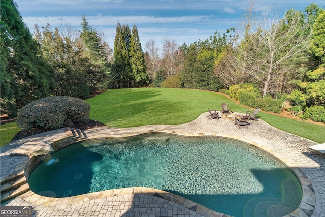 pool featuring a patio area, a lawn, and an outdoor fire pit