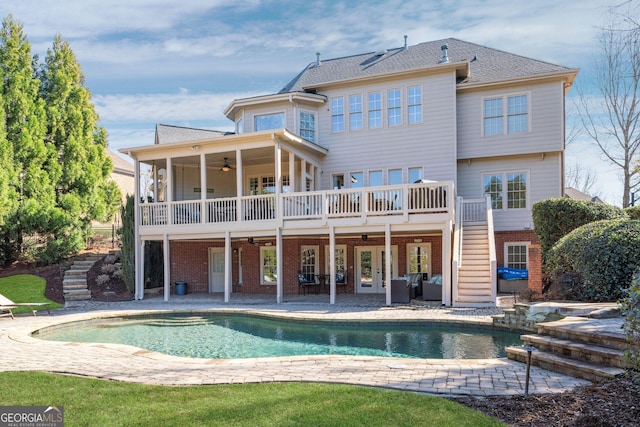 rear view of property with brick siding, stairway, a patio, and a deck