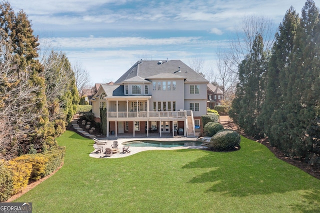 rear view of property with stairs, a lawn, a deck, a patio area, and an outdoor pool