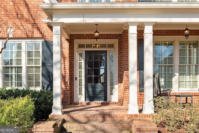 property entrance with brick siding and covered porch