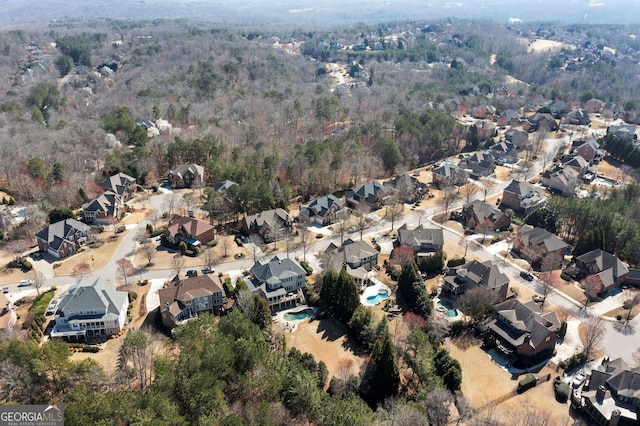 drone / aerial view featuring a residential view and a wooded view