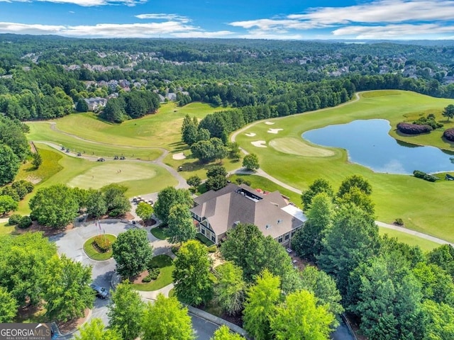 drone / aerial view with a water view, a view of trees, and golf course view