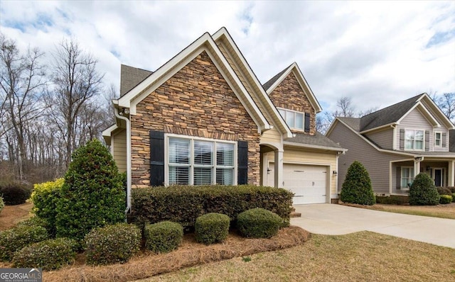 craftsman-style home featuring a garage, stone siding, and driveway