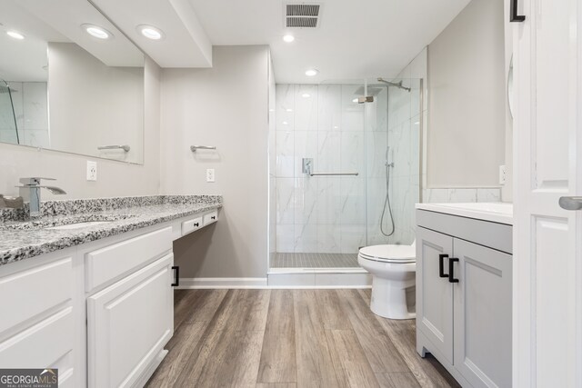 3481 Lakeside Dr NE Unit 2303, Atlanta, GA 30326 - bathroom with vanity, wood finished floors, visible vents, a marble finish shower, and toilet