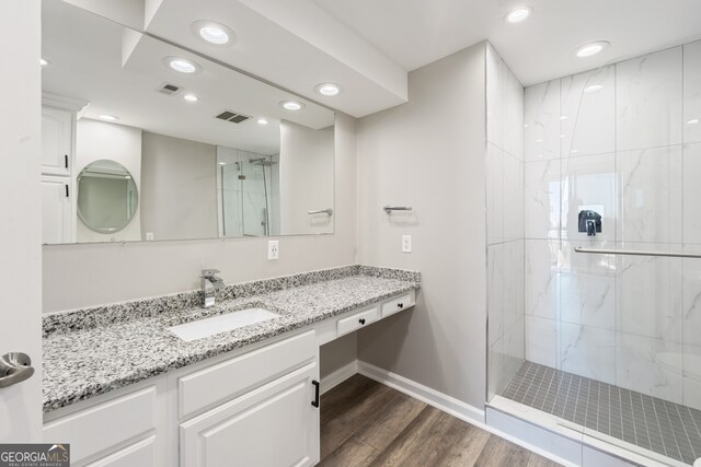 3481 Lakeside Dr NE Unit 2303, Atlanta, GA 30326 - bathroom featuring vanity, wood finished floors, visible vents, and a marble finish shower