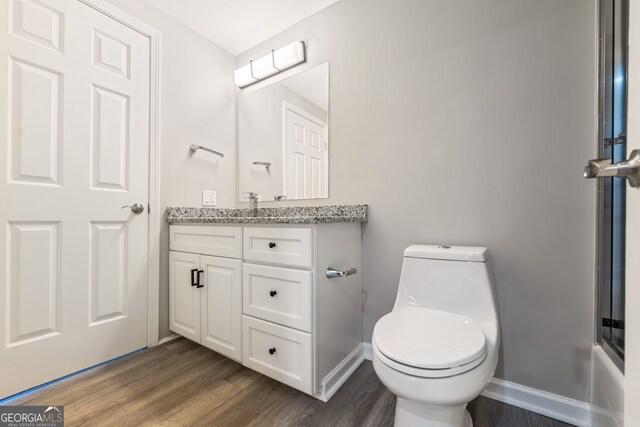 3481 Lakeside Dr NE Unit 2303, Atlanta, GA 30326 - bathroom featuring vanity, toilet, wood finished floors, and baseboards