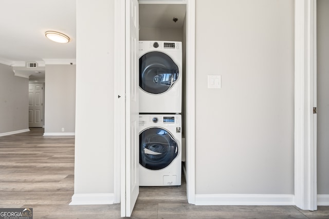 3481 Lakeside Dr NE Unit 2303, Atlanta, GA 30326 - laundry room featuring estacked washer and dryer, wood finished floors, and crown molding