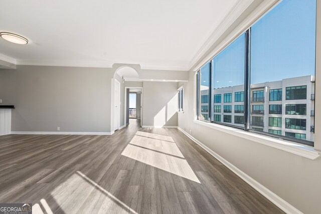 3481 Lakeside Dr NE Unit 2303, Atlanta, GA 30326 - unfurnished living room with baseboards, wood finished floors, arched walkways, and ornamental molding