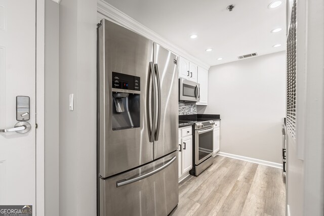 3481 Lakeside Dr NE Unit 2303, Atlanta, GA 30326 - kitchen with visible vents, light wood-style flooring, dark countertops, white cabinetry, and stainless steel appliances
