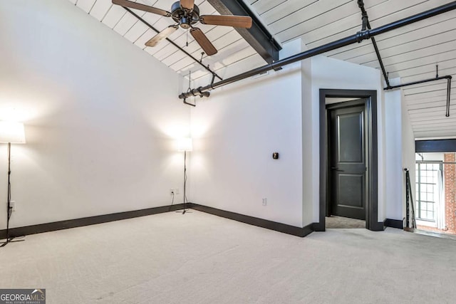 carpeted empty room featuring vaulted ceiling with beams, wood ceiling, a ceiling fan, and baseboards