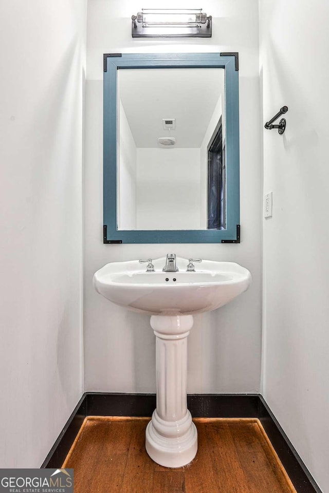 bathroom with visible vents, baseboards, and wood finished floors