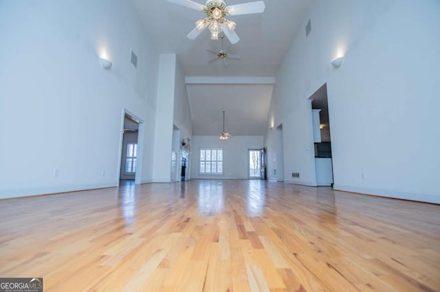 unfurnished living room with baseboards, ceiling fan, visible vents, and wood finished floors