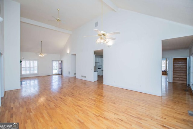 unfurnished living room with ceiling fan, beamed ceiling, and light wood-type flooring