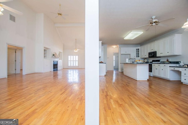 kitchen featuring gas stove, open floor plan, visible vents, and ceiling fan