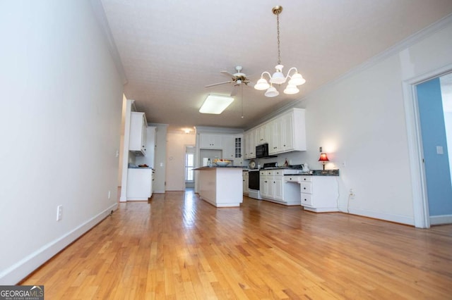 kitchen with dark countertops, gas range, open floor plan, and crown molding