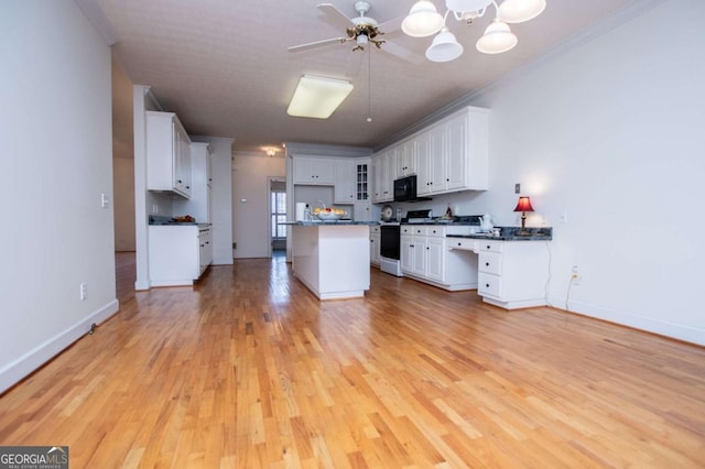 kitchen featuring dark countertops, crown molding, and gas range oven