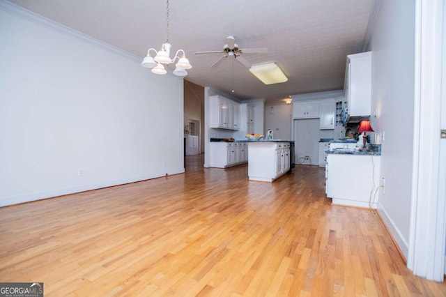 kitchen with light wood-type flooring, dark countertops, open floor plan, and white cabinetry