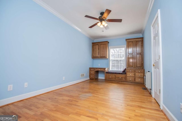 unfurnished bedroom with radiator heating unit, ornamental molding, built in study area, light wood-type flooring, and baseboards