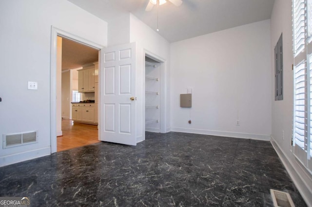 unfurnished bedroom with electric panel, visible vents, ceiling fan, and baseboards