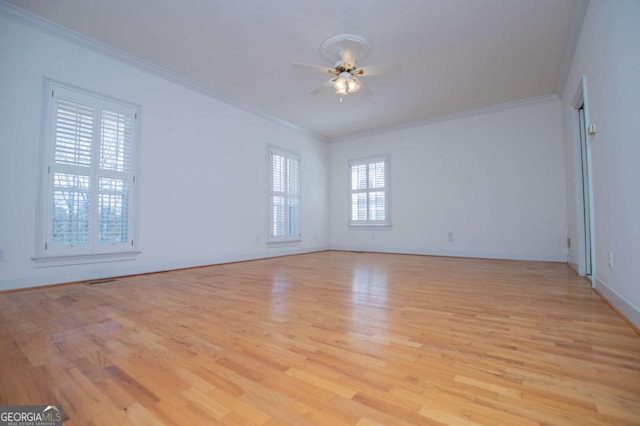 unfurnished room with ornamental molding, light wood-style floors, baseboards, and a ceiling fan