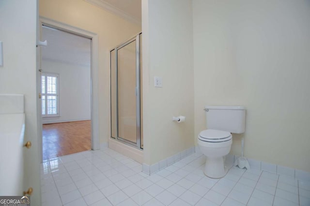 full bathroom featuring ornamental molding, a stall shower, toilet, and tile patterned floors