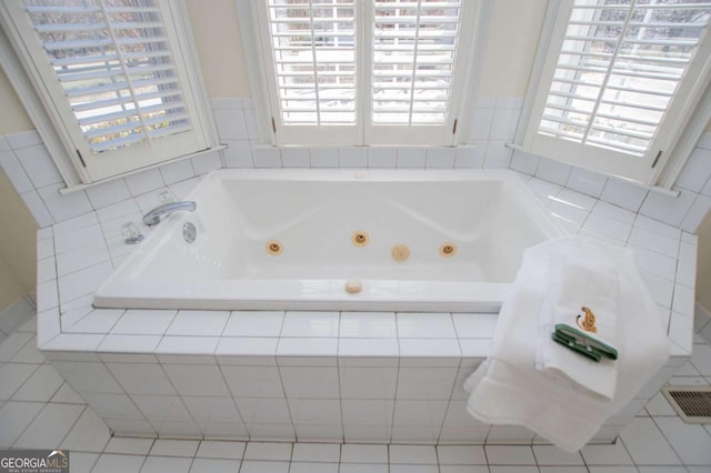 bathroom with visible vents, plenty of natural light, and a jetted tub