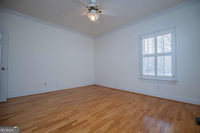 empty room with baseboards, light wood finished floors, and crown molding