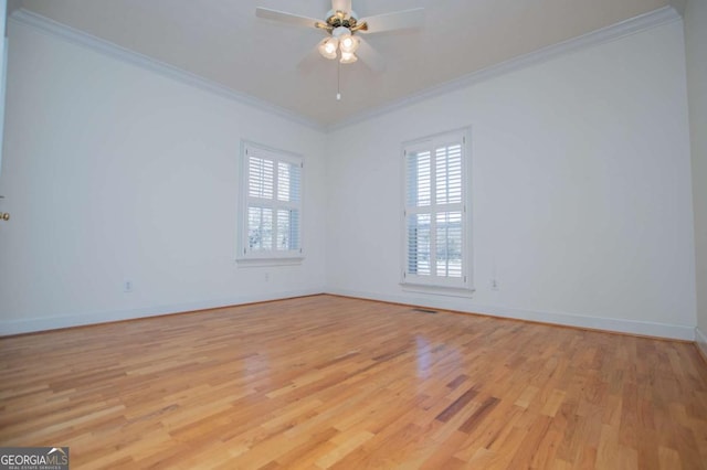 spare room featuring baseboards, crown molding, light wood finished floors, and ceiling fan