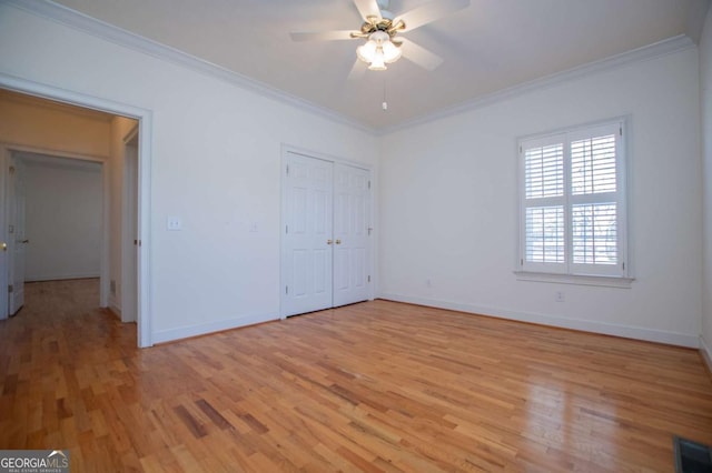 unfurnished bedroom featuring light wood-style flooring, visible vents, baseboards, and crown molding