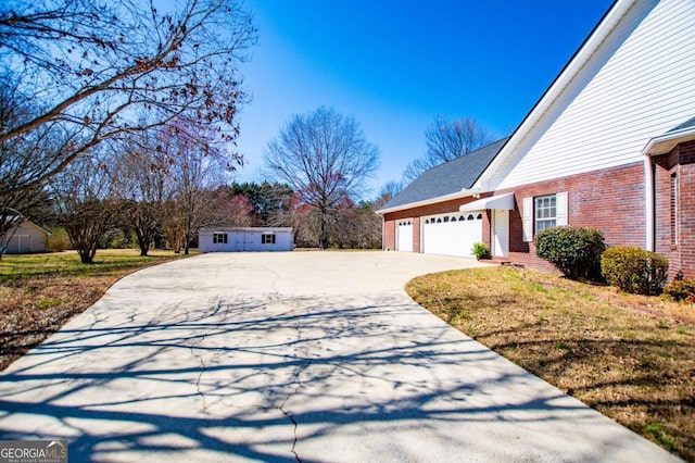 view of property exterior with driveway, brick siding, and an attached garage