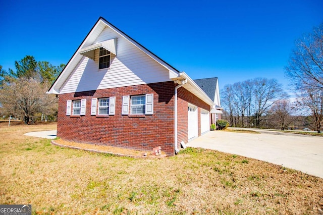 view of home's exterior with a yard, concrete driveway, brick siding, and a garage