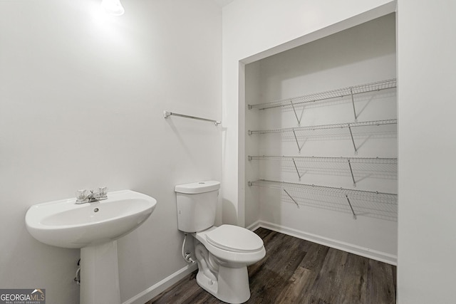 bathroom featuring toilet, baseboards, and wood finished floors