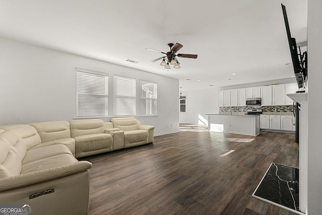 unfurnished living room with ceiling fan, dark wood-style flooring, and visible vents