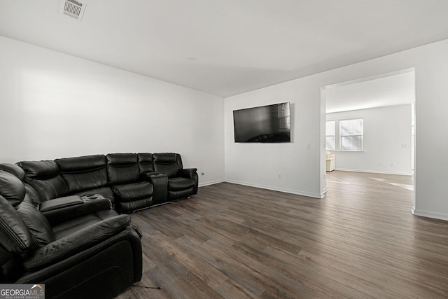 living room featuring baseboards, visible vents, and wood finished floors