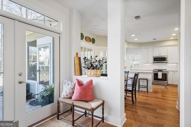 sitting room with recessed lighting, visible vents, a healthy amount of sunlight, and light wood-style flooring