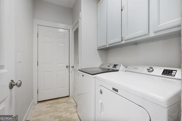 washroom featuring baseboards, cabinet space, and washer and clothes dryer