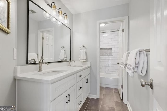 full bathroom with tile patterned flooring, double vanity, baseboards, and a sink