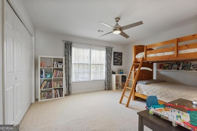 carpeted bedroom with visible vents, a ceiling fan, a closet, and baseboards