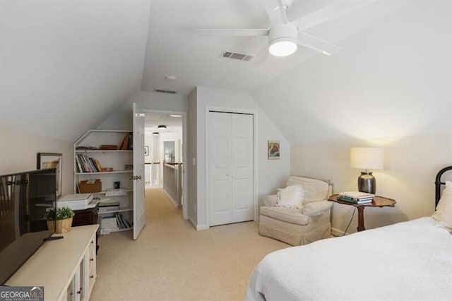 bedroom featuring visible vents, ceiling fan, vaulted ceiling, a closet, and light colored carpet