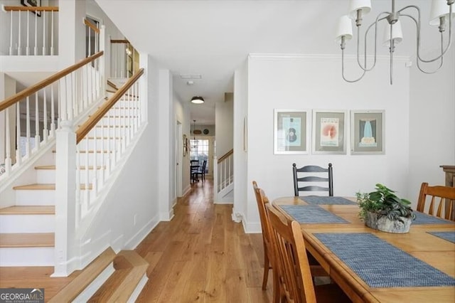 dining area with stairway, baseboards, and wood finished floors