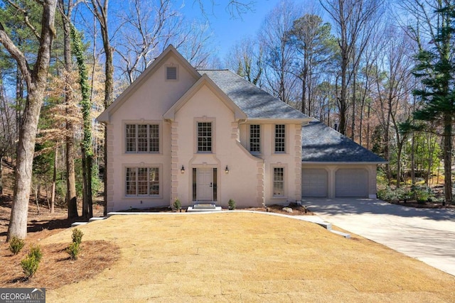 view of front of house featuring stucco siding, a front lawn, driveway, a shingled roof, and a garage