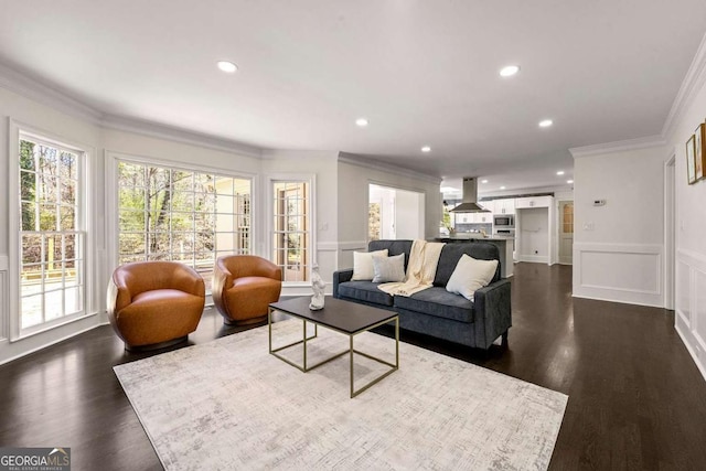 living area with recessed lighting, dark wood-style floors, ornamental molding, and a decorative wall