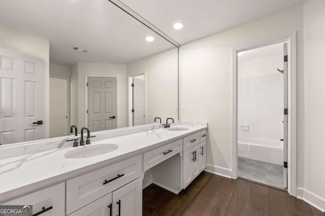 bathroom featuring double vanity, visible vents, wood finished floors, and a sink