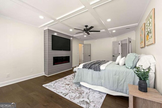 bedroom with coffered ceiling, a large fireplace, baseboards, and wood finished floors