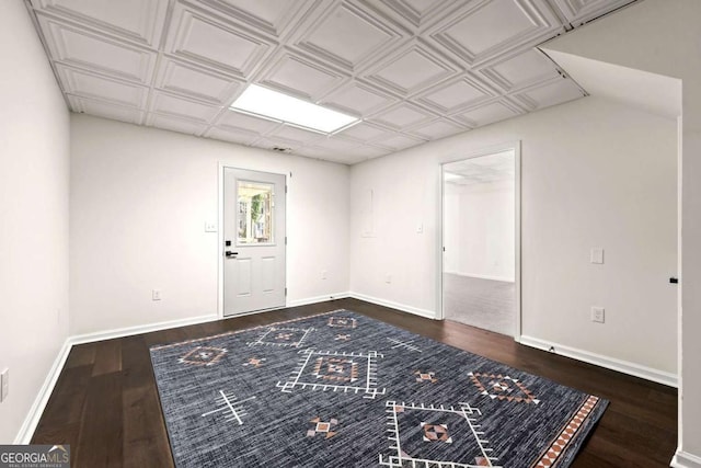 empty room featuring an ornate ceiling, baseboards, and dark wood-style flooring