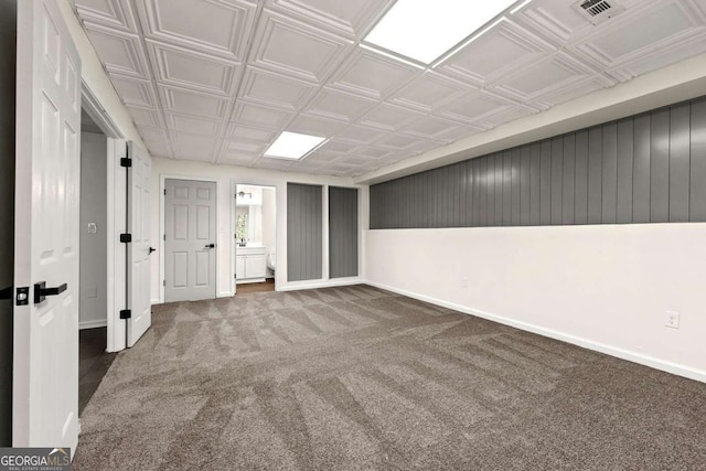 carpeted spare room featuring visible vents, an ornate ceiling, and baseboards