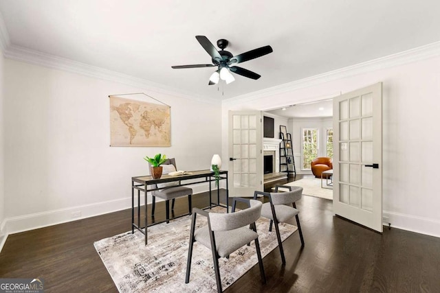 office space with baseboards, wood finished floors, a fireplace with raised hearth, and ornamental molding