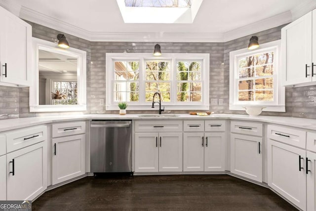 kitchen featuring dark wood-type flooring, a sink, white cabinetry, a skylight, and dishwasher