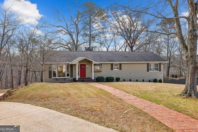 ranch-style home with a chimney and a front yard