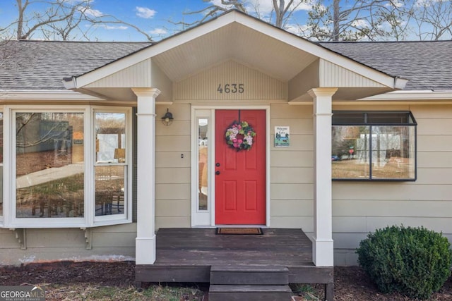 entrance to property featuring a shingled roof